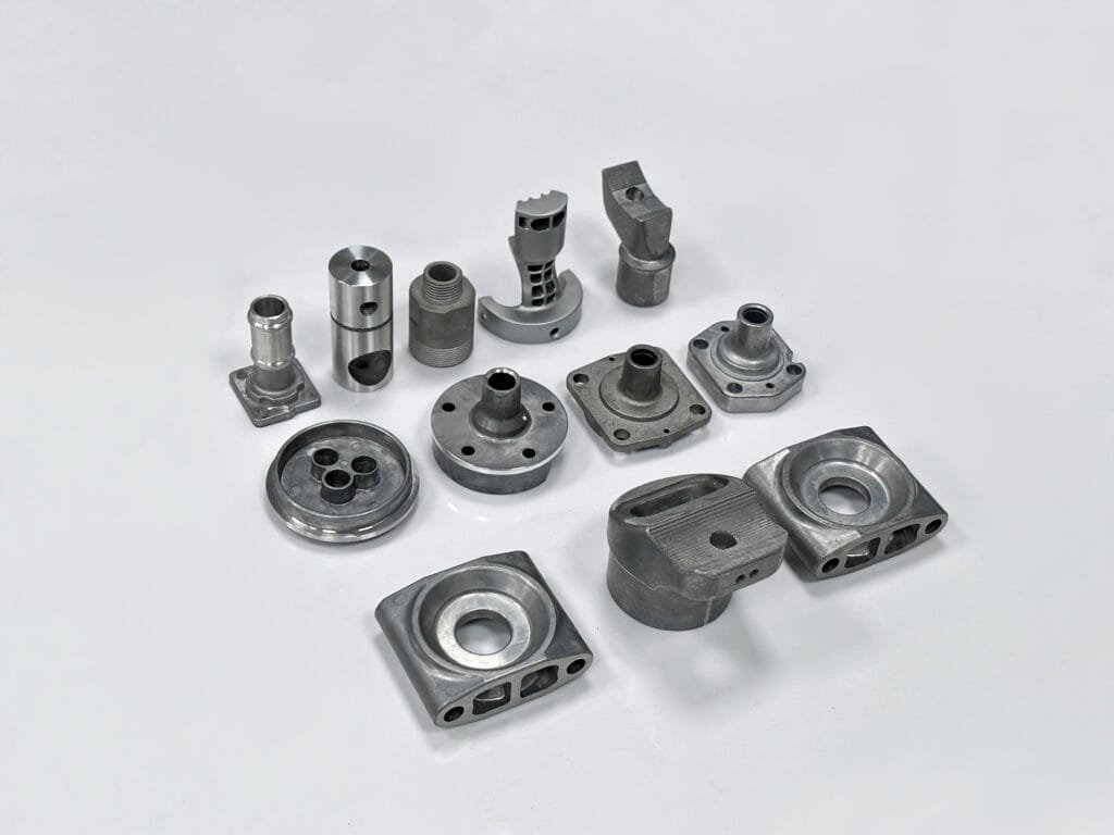 Technician inspecting a zinc die casting component for precision and surface quality at Cast-Mold’s manufacturing facility.