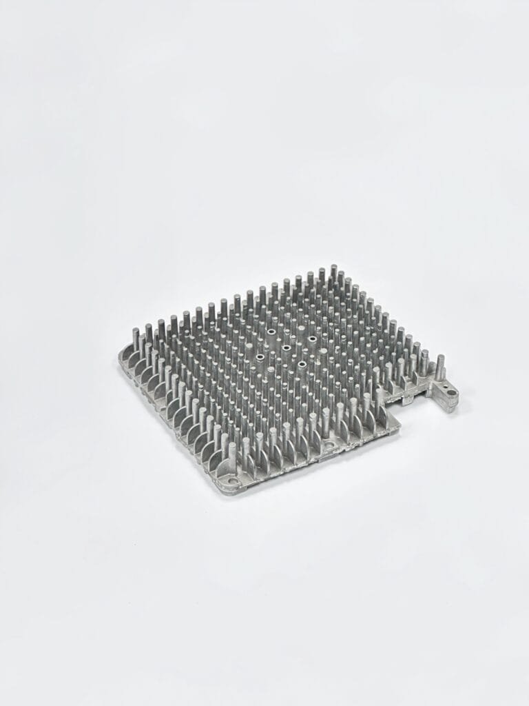 Close-up of a finned heat sink die-cast from A380 aluminum, showing thin walls, mounting bosses, and airflow channels.