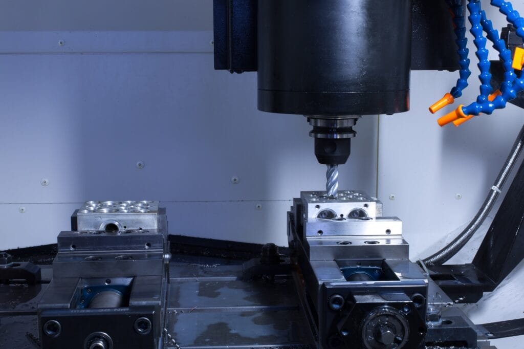 CNC machining equipment performing high-precision milling on a metal part at Cast-Mold’s facility.
