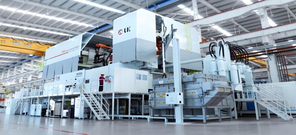 State-of-the-Art Aluminum Die Casting Machine A spacious, brightly lit factory floor housing a large, white high-pressure aluminum die casting machine with robotic arms and a worker in safety gear operating controls.