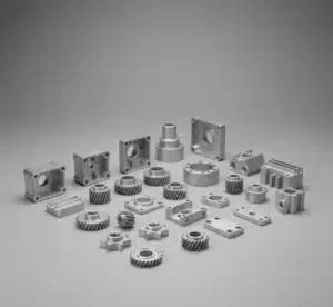 Assorted zinc die-cast parts made from Zamak alloy 3 and Zamak 5—housings, gears, brackets, and plates—arranged on a neutral gray background in a catalog-style shot showing fine casting texture and machined features.