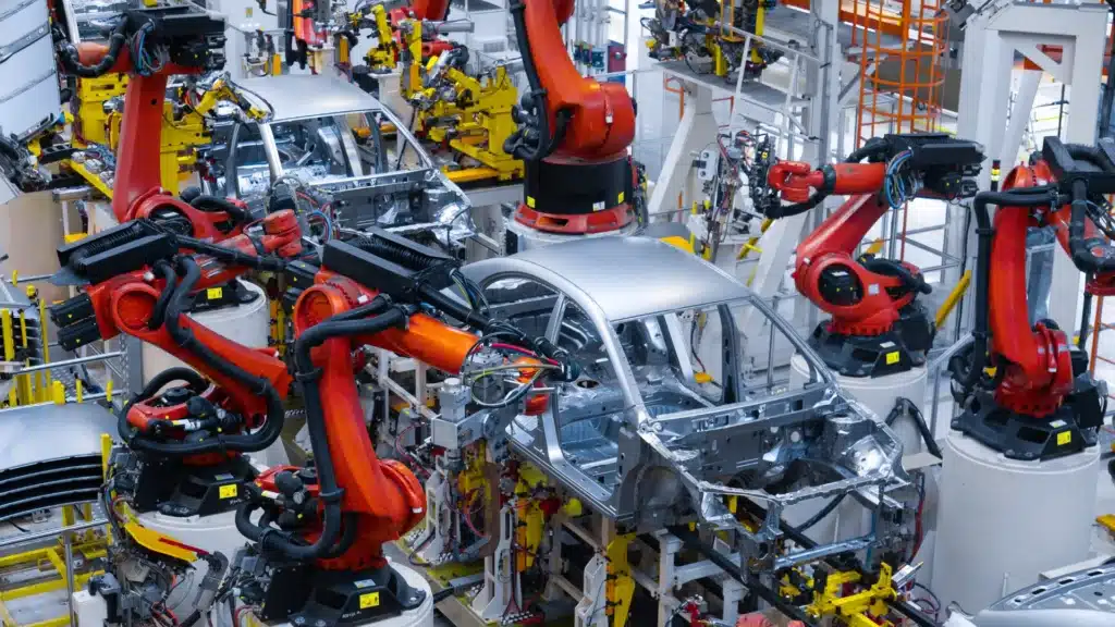 Robotic arms assembling a car body-in-white on an automated automotive production line.