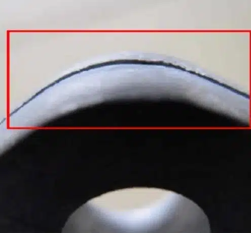 Aluminum die casting cold-shut / weld line on edge—dark seam where flow fronts met.