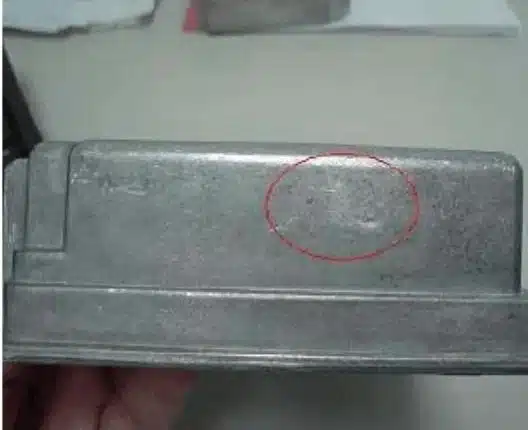 Aluminum HPDC defect—sink mark (local shrinkage depression) highlighted on a flat cosmetic face.