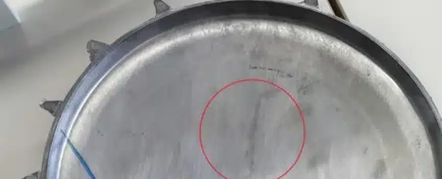 Flow mark on an aluminum die-cast cookware lid highlighted by a red circle