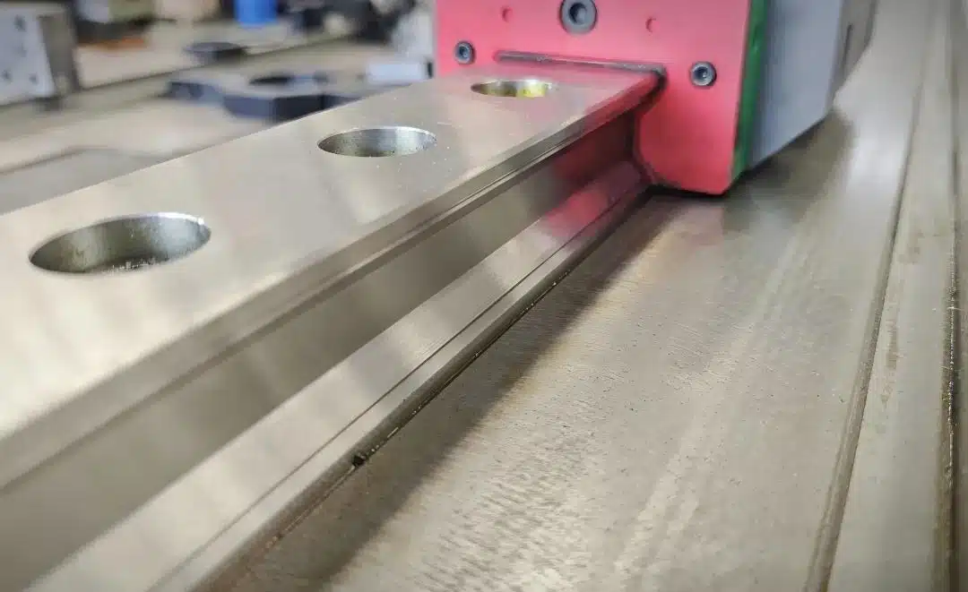 Guía lineal de precisión y bloque de cojinete utilizados en una máquina CNC.