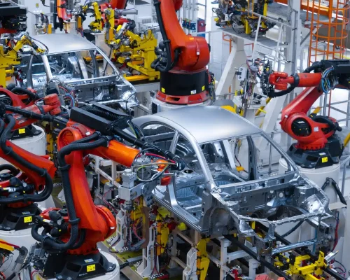 Robotic arms assembling a car body-in-white on an automated automotive production line.