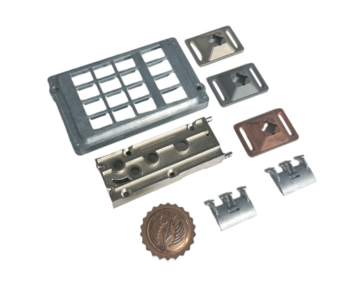 A set of precision zinc die casting parts—including inserts, housings, and decorative emblems—arranged on a white background.