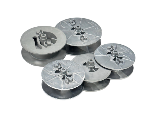 A set of round, disc-shaped metal prototypes arranged on a white background.